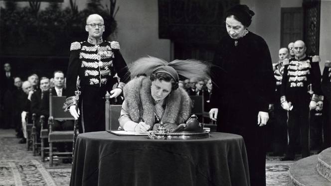 Hare Majesteit Koningin Juliana bekrachtigt op 15 december 1954 in de Ridderzaal te Den Haag met haar handtekening het Statuut voor het Koninkrijk der Nederlanden